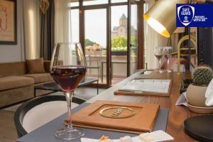 第比利斯第比利斯宫殿酒店的客厅的桌子上放着一杯葡萄酒