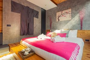 奈汉海滩Cozy design studio near Nai Harn beach的一间卧室设有一张大床,上面有两只填充动物