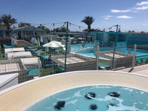 马斯帕洛马斯Venus Star Resort - FKK Nudist Swingers - Only Couples的享有游泳池的景色,游泳池内饲养着笼子里的动物