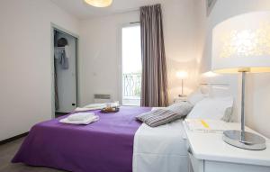 格雷乌莱班Terres de France - Résidence Côté Provence的酒店客房设有紫色的床和窗户。