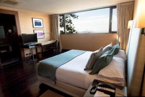 瓦尔帕莱索卡萨伊格拉斯酒店的酒店客房设有一张床和一张带窗户的书桌
