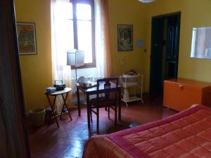 亚历山德里亚B&B Casa Manuelli的一间带桌子的卧室和一间带床的房间
