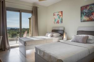 卡拉瓦杜斯Sailing Villa Kefalonia的卧室设有两张床,享有阳台的景色