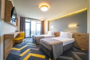 阳光海滩HVD Club Bor - 24 Hours Ultra All Inclusive的酒店客房配有两张床和一张书桌