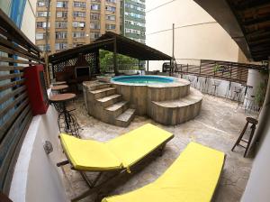 里约热内卢拉加托科帕卡巴纳旅馆的庭院设有游泳池、椅子和桌子。