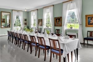 克里斯蒂安桑Boen Gård的一间长长的用餐室,配有白色的桌子和椅子