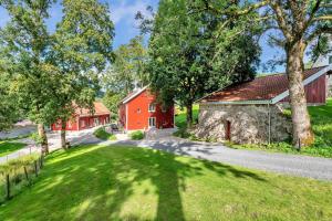 克里斯蒂安桑Boen Gård的红谷仓和树的图象