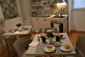 塔兰托Lo Schiaccianoci B&B的厨房配有2张桌子和椅子,并备有食物