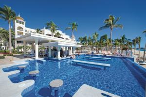 卡波圣卢卡斯Riu Palace Cabo San Lucas - All Inclusive的棕榈树度假村的游泳池