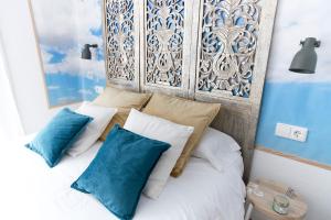 马德里格兰大道巴斯克斯德梅拉旅馆的一间卧室配有一张带蓝色和白色枕头的床