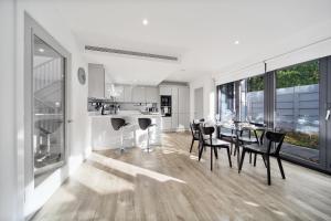 伦敦Executive Apartments in Bermondsey FREE WIFI & AIRCON by City Stay Aparts London的厨房以及带桌椅的用餐室。