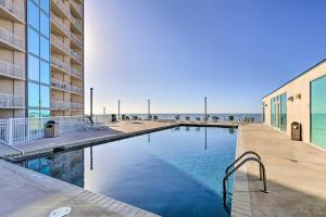比洛克西Sunny Beachfront Biloxi Condo with Resort Amenities!的一座游泳池毗邻一座建筑和大海