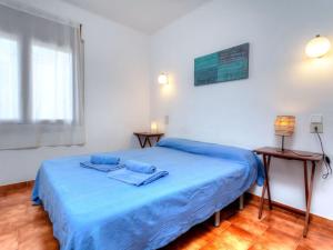 兰卡Apartment Sant Carles by Interhome的一间卧室配有一张带蓝色床单的床和一扇窗户。