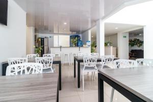 波哥大Hotel Federman Park Bogota的一间设有白色椅子和桌子的用餐室