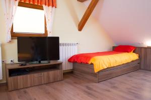 LomeCharming countryside house的一间卧室配有一张床和一台平面电视