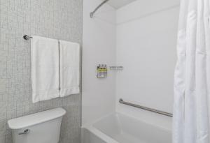 萨斯卡通智选假日酒店 - 萨斯卡通东 - 大学的浴室设有卫生间和带毛巾的淋浴。