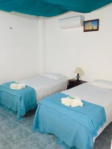 比亚米尔港Hospedaje Sarita的蓝色和白色的客房内的两张床