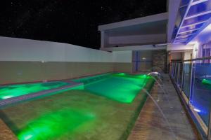 圣安德烈斯Ocean Blue Beach的室内游泳池,晚上提供绿水