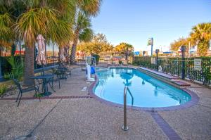 休斯顿休斯敦北智选假日套房洲际酒店的公园里的小型游泳池,配有桌椅
