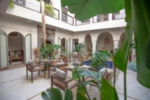 马拉喀什法尔汉庭院旅馆的客厅配有桌椅和植物