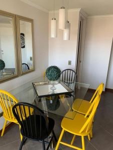 安托法加斯塔MATI´S APARTAMENT的一间设有玻璃桌和黄色椅子的用餐室