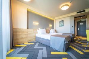 阳光海滩HVD Club Bor - 24 Hours Ultra All Inclusive的酒店客房,设有两张黄色和蓝色的床铺