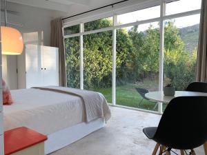 弗朗斯胡克Gite的一间卧室配有一张床、一张桌子和一个大窗户