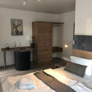 科布伦茨Hotel Berghof by 42的一间卧室配有一张床和一张书桌