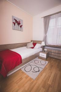 普拉特恩祖尔赛琳娜宾馆的一间卧室配有一张床和红色毯子