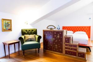 卢加诺Al Ciani Balcony Suite的一间卧室配有一张床、一把椅子和一张桌子