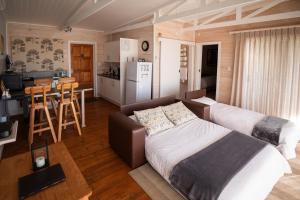WolseleyBig Sky Cottages的一间卧室配有一张床,厨房配有桌子