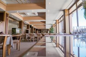 YusufkhonaAvenue Park Hotel的用餐室设有桌椅和窗户。