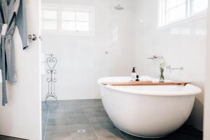 Lights PassTomfoolery Winemaker's Cottage Barossa Valley的浴室配有白色浴缸和水槽