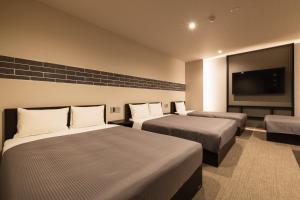 福冈GRAND BASE Hakata Naraya的酒店客房设有两张床和一台平面电视。