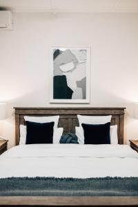 Lights PassTomfoolery Winemaker's Cottage Barossa Valley的卧室配有一张带白色床单和枕头的大床。