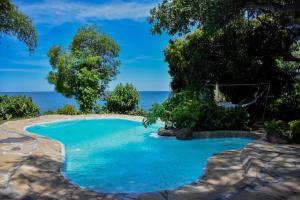 MbitaMfangano Island Lodge的一座背景海洋的游泳池