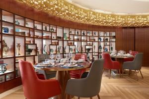 迪拜香格里拉公寓酒店的一间带桌椅和书架墙的用餐室