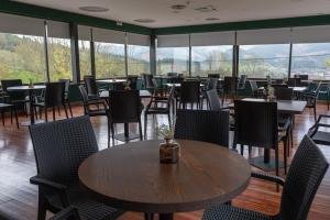 奥尼亚特Soraluze Hotela的用餐室设有桌椅和窗户。