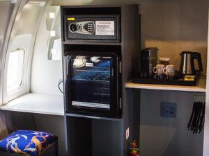 侯斯普瑞特Aerotel的微波炉烤箱坐在房间的墙上