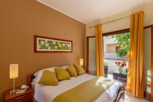 圣维托罗卡波Residence Smeraldo的一间卧室配有一张带黄色枕头的床和一扇窗户