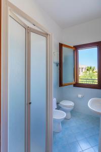 圣维托罗卡波Residence Smeraldo的浴室设有2个卫生间、水槽和窗户。