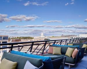 华盛顿citizenM Washington DC Capitol的阳台配有沙发,享有建筑的景色