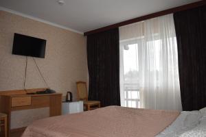 Malaya BugayevkaFG Dzherelo S的一间卧室设有一张床和一个带电视的窗户。