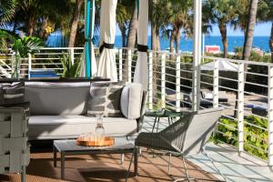 迈阿密海滩金普顿赛康贝酒店的一个带沙发和椅子的庭院和海滩