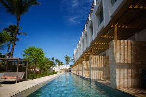 蓬塔卡纳Princess Family Club Bavaro - All Inclusive的棕榈树建筑旁边的游泳池