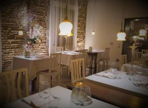 Fratta PolesineAlbergo Ristorante Palladio Osteria dal 1900的餐厅配有白色的桌椅和灯光