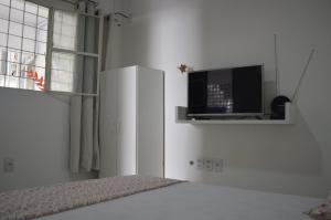 马塞约Pousada Marazul的一间白色卧室,配有电视和一张床
