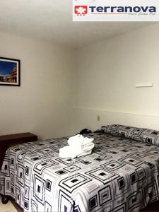 莱昂泰拉诺瓦酒店的一间卧室配有一张带黑白色棉被的床