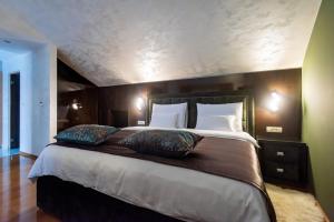 苏科尚Suites Kod Guste的一间卧室配有一张大床和两个枕头