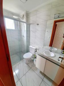 大普拉亚Apartamento Mirim Praia Grande的白色的浴室设有卫生间和水槽。